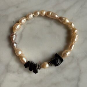 Vintage fresh water pearl and black matte stone bracelet on a stretch strand.